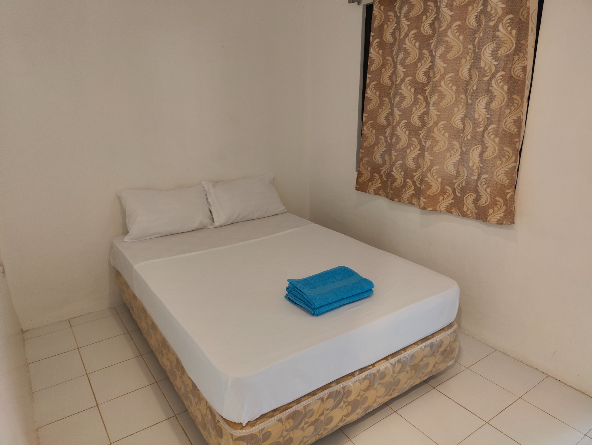 Double bed prepared with clean bedding and towels